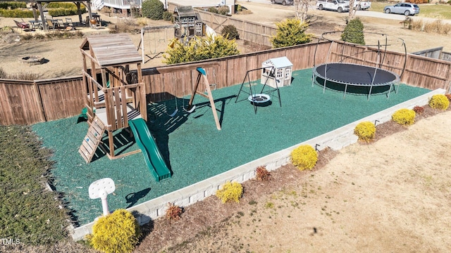 view of jungle gym featuring a trampoline and a fenced backyard