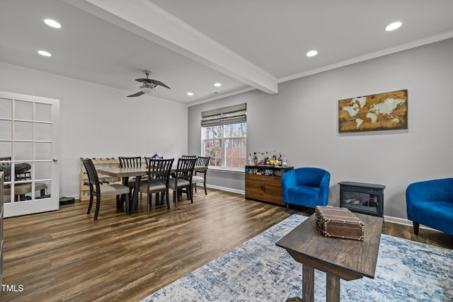 dining room with ceiling fan, dark wood-type flooring, ornamental molding, and beamed ceiling