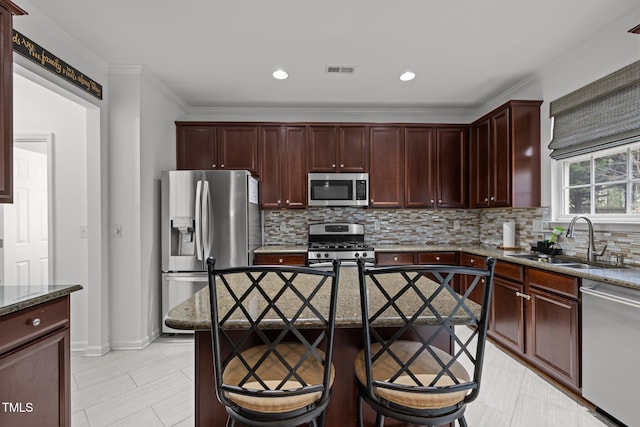 kitchen featuring sink, light stone counters, tasteful backsplash, ornamental molding, and stainless steel appliances