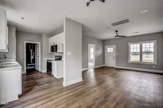 unfurnished living room with hardwood / wood-style flooring, ceiling fan, plenty of natural light, and sink