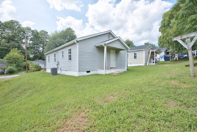 view of side of home with a lawn and central air condition unit