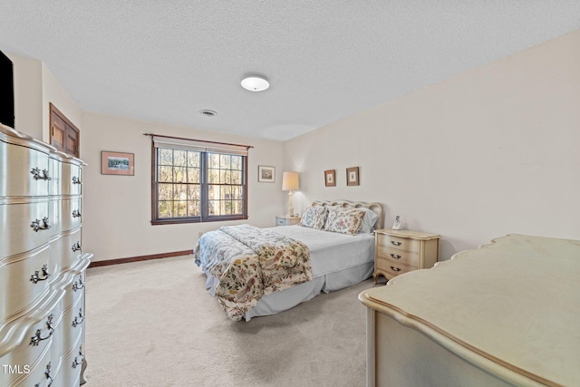 bedroom featuring light colored carpet and a textured ceiling