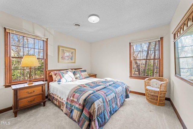 bedroom featuring light carpet and a textured ceiling