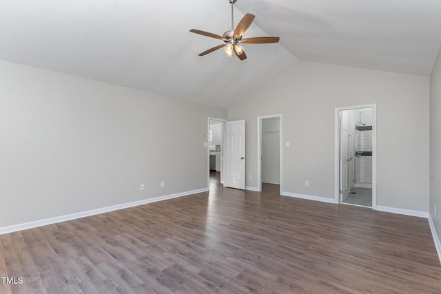 unfurnished bedroom with ensuite bathroom, high vaulted ceiling, a spacious closet, and dark hardwood / wood-style flooring