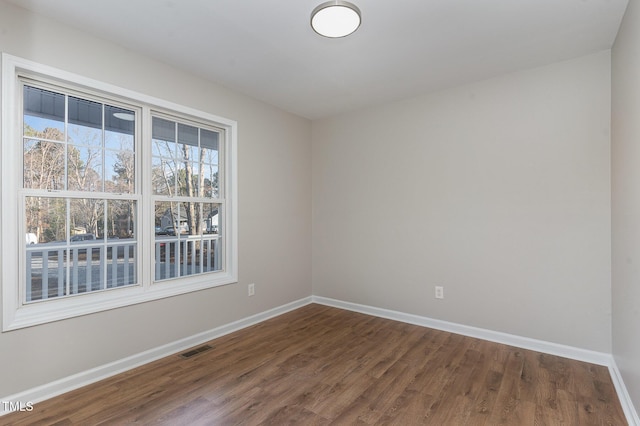 unfurnished room with dark hardwood / wood-style flooring