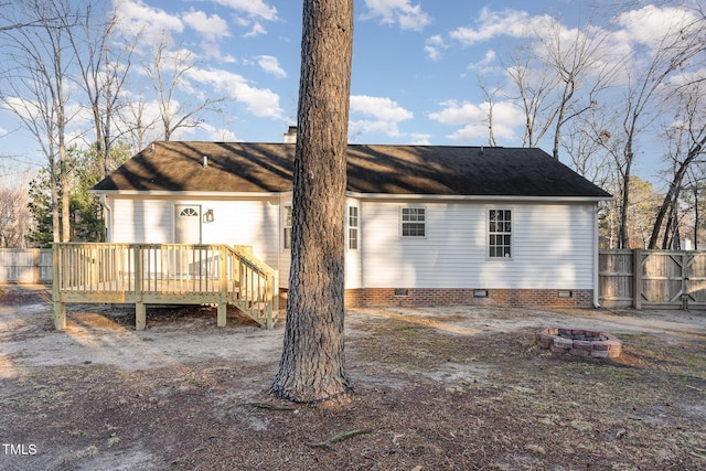 back of house with a wooden deck and an outdoor fire pit