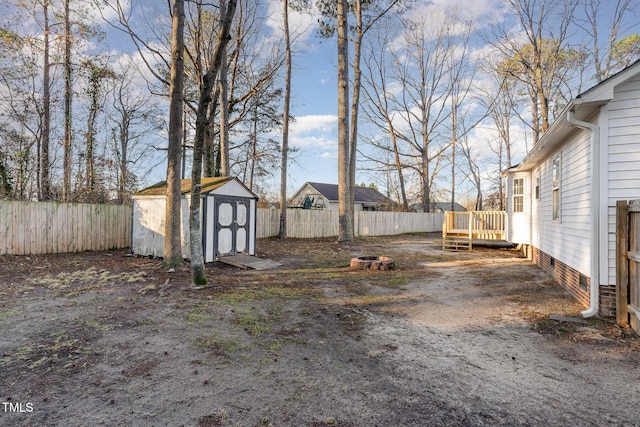 view of yard featuring a wooden deck and a storage unit