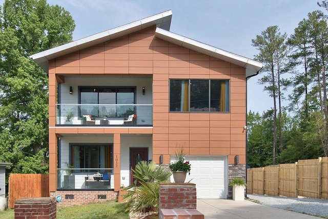 contemporary house featuring a garage and a balcony