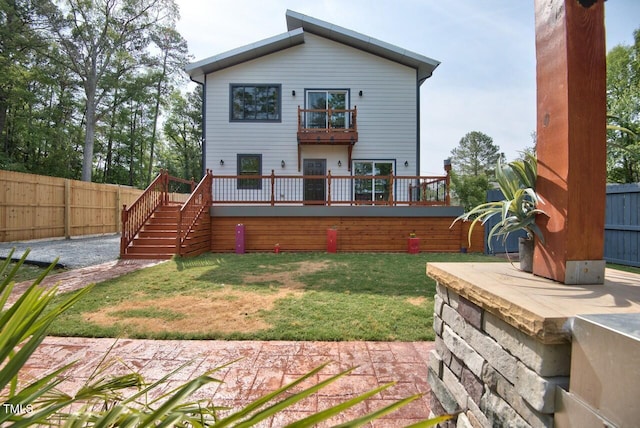 rear view of property featuring a lawn and a balcony