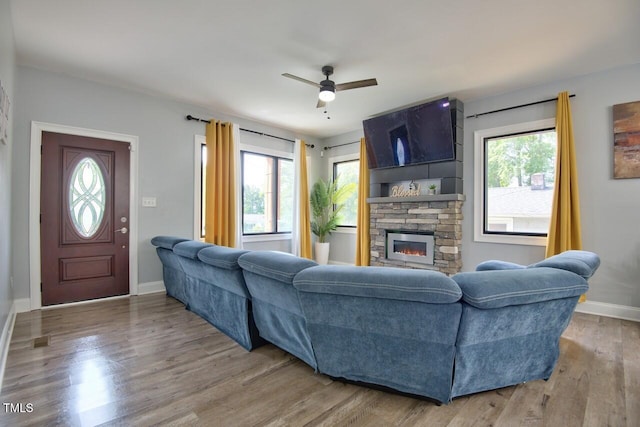 living room with ceiling fan, hardwood / wood-style flooring, a fireplace, and a healthy amount of sunlight