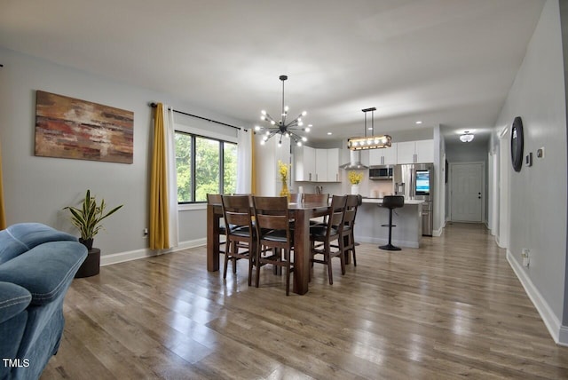 dining area with hardwood / wood-style floors and a notable chandelier