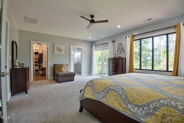 bedroom featuring ceiling fan, access to exterior, connected bathroom, light carpet, and a walk in closet