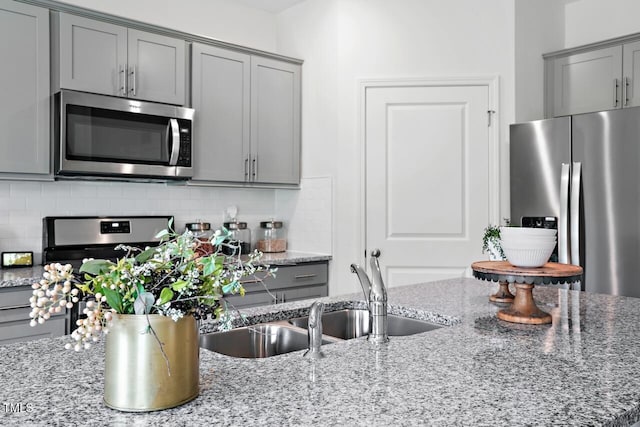 kitchen featuring stone counters, tasteful backsplash, and appliances with stainless steel finishes