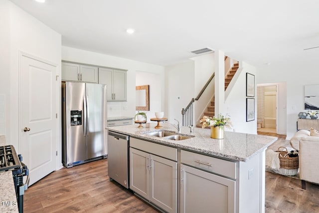 kitchen featuring sink, gray cabinets, light stone countertops, and appliances with stainless steel finishes