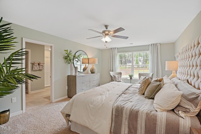 bedroom with connected bathroom, light carpet, and ceiling fan