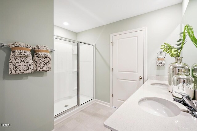 bathroom with vanity and a shower with shower door