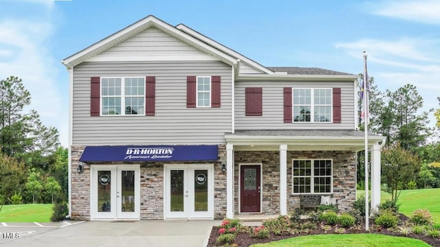 view of front of house with french doors and a front lawn