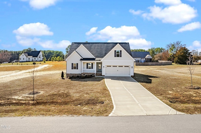 modern inspired farmhouse with concrete driveway, a front lawn, and fence