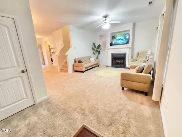 carpeted living room featuring ceiling fan