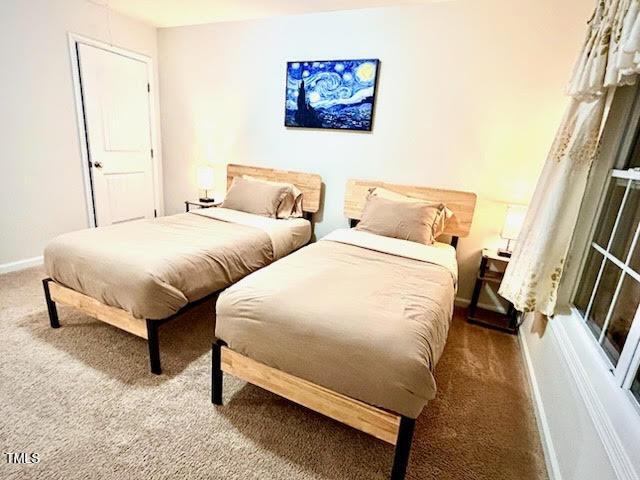 carpeted bedroom featuring baseboards