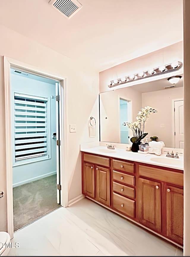 bathroom featuring double vanity, a sink, and visible vents