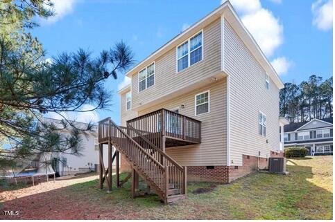 back of property featuring central AC unit, a deck, a yard, a trampoline, and stairs