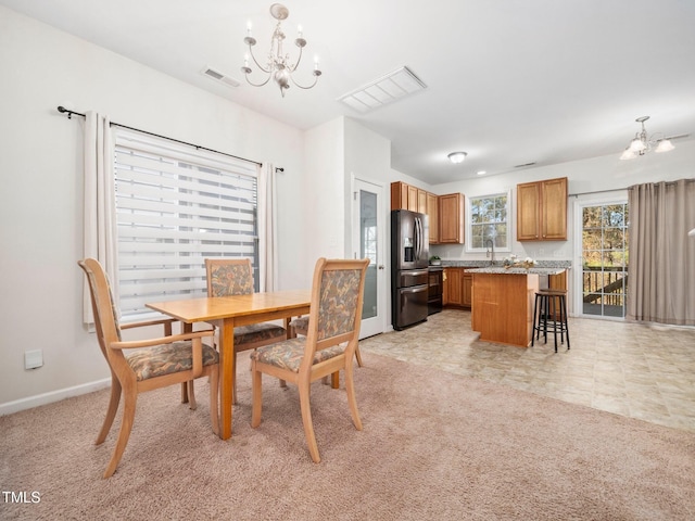 dining area with a chandelier, light carpet, baseboards, and visible vents