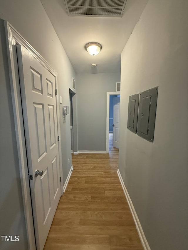 hallway with wood-type flooring and electric panel