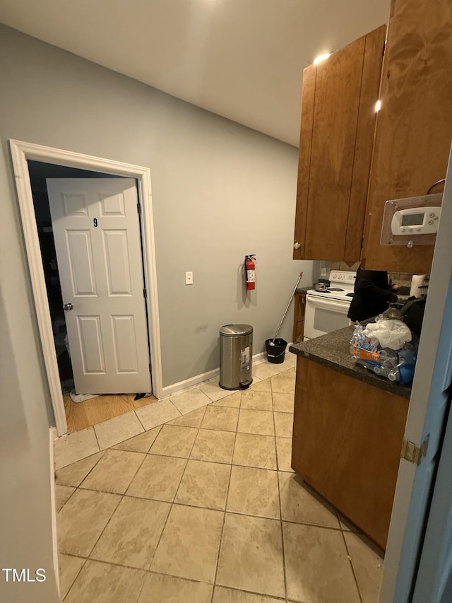 kitchen featuring white electric range oven and light tile patterned floors