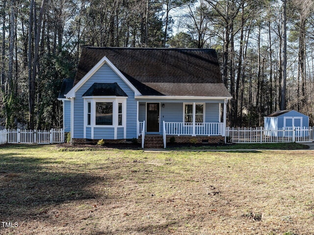 view of front facade featuring a porch, a storage shed, and a front lawn