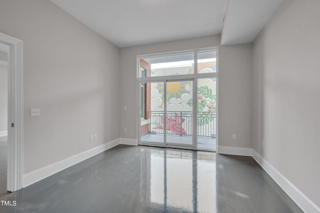 unfurnished room with concrete flooring