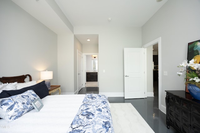 bedroom featuring baseboards, recessed lighting, finished concrete flooring, and ensuite bathroom
