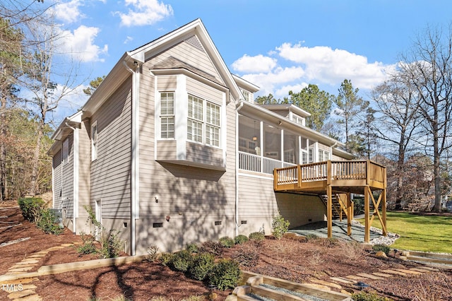 view of side of home with a sunroom and a deck