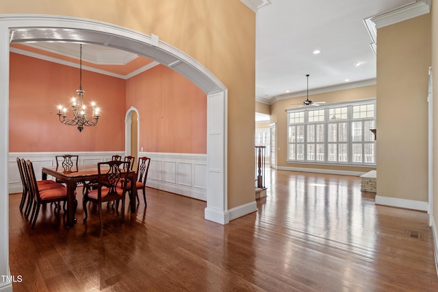 dining room with crown molding, ceiling fan with notable chandelier, and hardwood / wood-style flooring