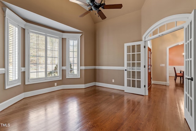 spare room featuring french doors, ceiling fan, wood-type flooring, and vaulted ceiling