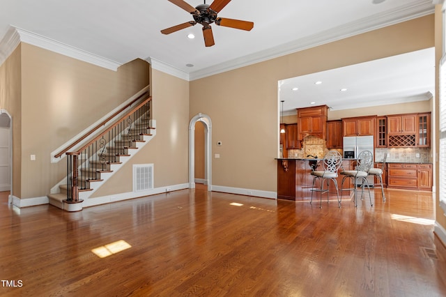 living room featuring hardwood / wood-style floors, crown molding, and ceiling fan