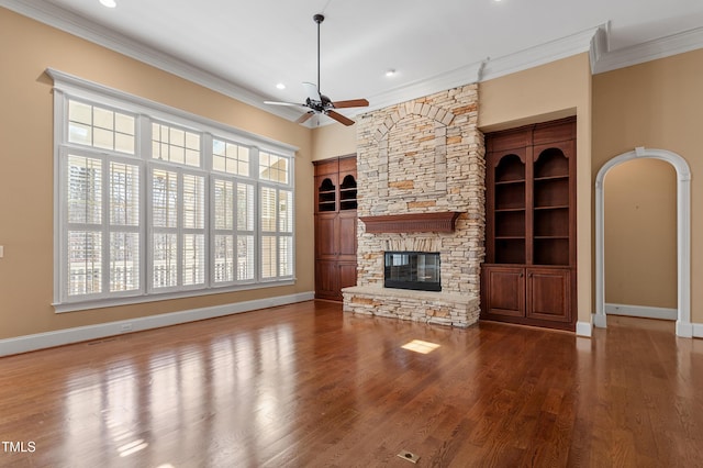 unfurnished living room featuring ornamental molding, hardwood / wood-style floors, ceiling fan, and a fireplace