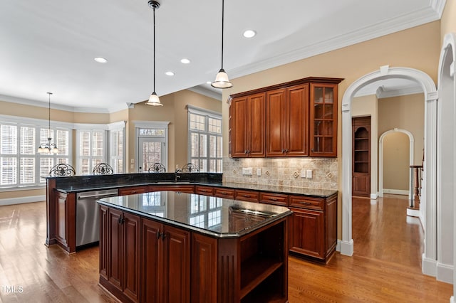 kitchen with pendant lighting, a center island, stainless steel dishwasher, and kitchen peninsula