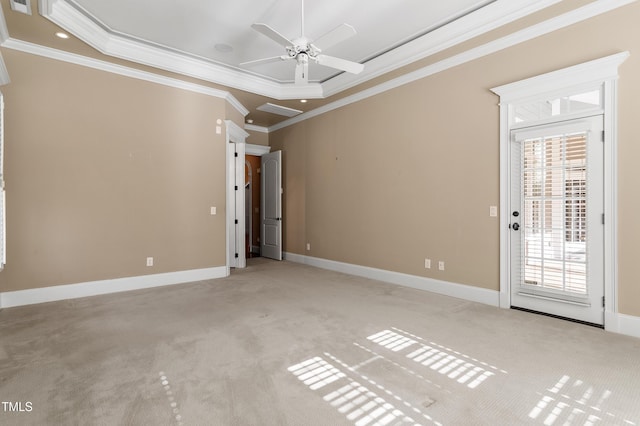 carpeted empty room featuring a raised ceiling, crown molding, and ceiling fan