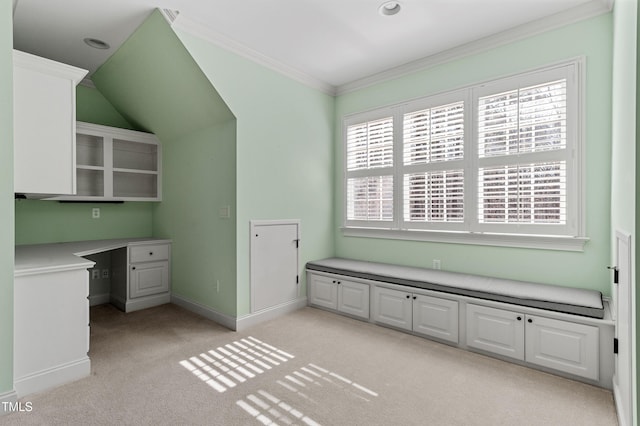 unfurnished office with crown molding, light colored carpet, and built in desk