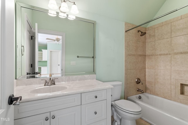 full bathroom featuring vaulted ceiling, tiled shower / bath combo, vanity, ceiling fan, and toilet