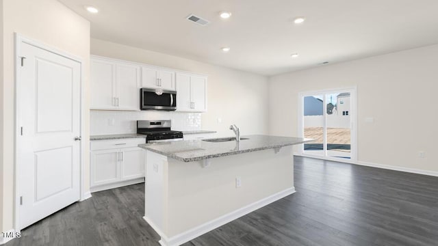 kitchen featuring white cabinetry, appliances with stainless steel finishes, sink, and a center island with sink