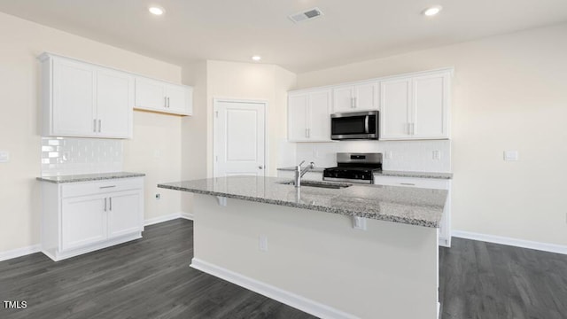 kitchen featuring sink, an island with sink, white cabinets, and appliances with stainless steel finishes