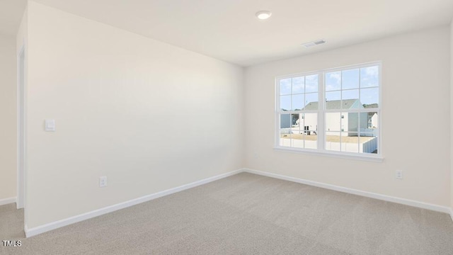 unfurnished room featuring light carpet