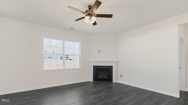 unfurnished living room featuring dark wood-type flooring and ceiling fan