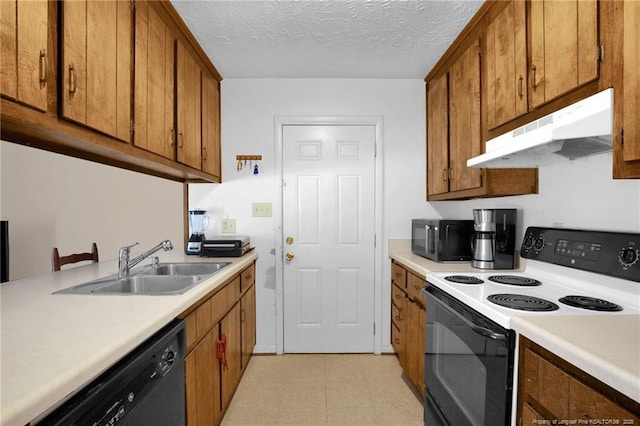 kitchen featuring sink, black appliances, and a textured ceiling