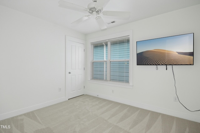 empty room with light colored carpet and ceiling fan