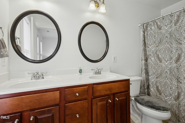 bathroom featuring vanity, a notable chandelier, and toilet