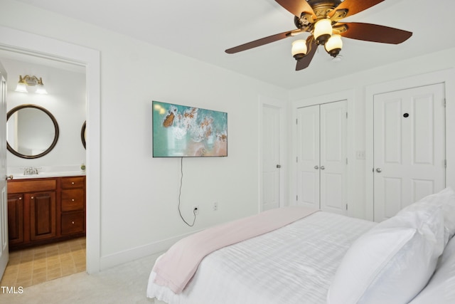 bedroom featuring ceiling fan, connected bathroom, sink, and a closet