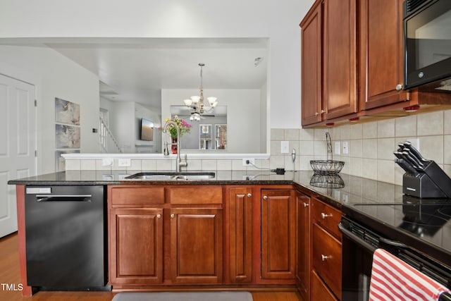 kitchen with sink, dark stone countertops, backsplash, black appliances, and an inviting chandelier